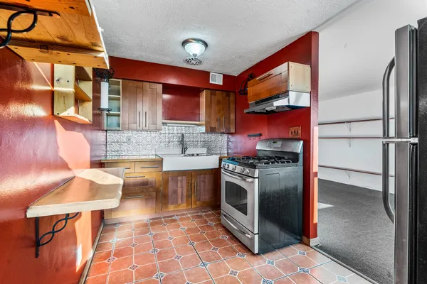 a kitchen with stainless steel appliances granite countertop a stove a sink and a refrigerator