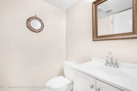 a bathroom with a toilet sink vanity and mirror
