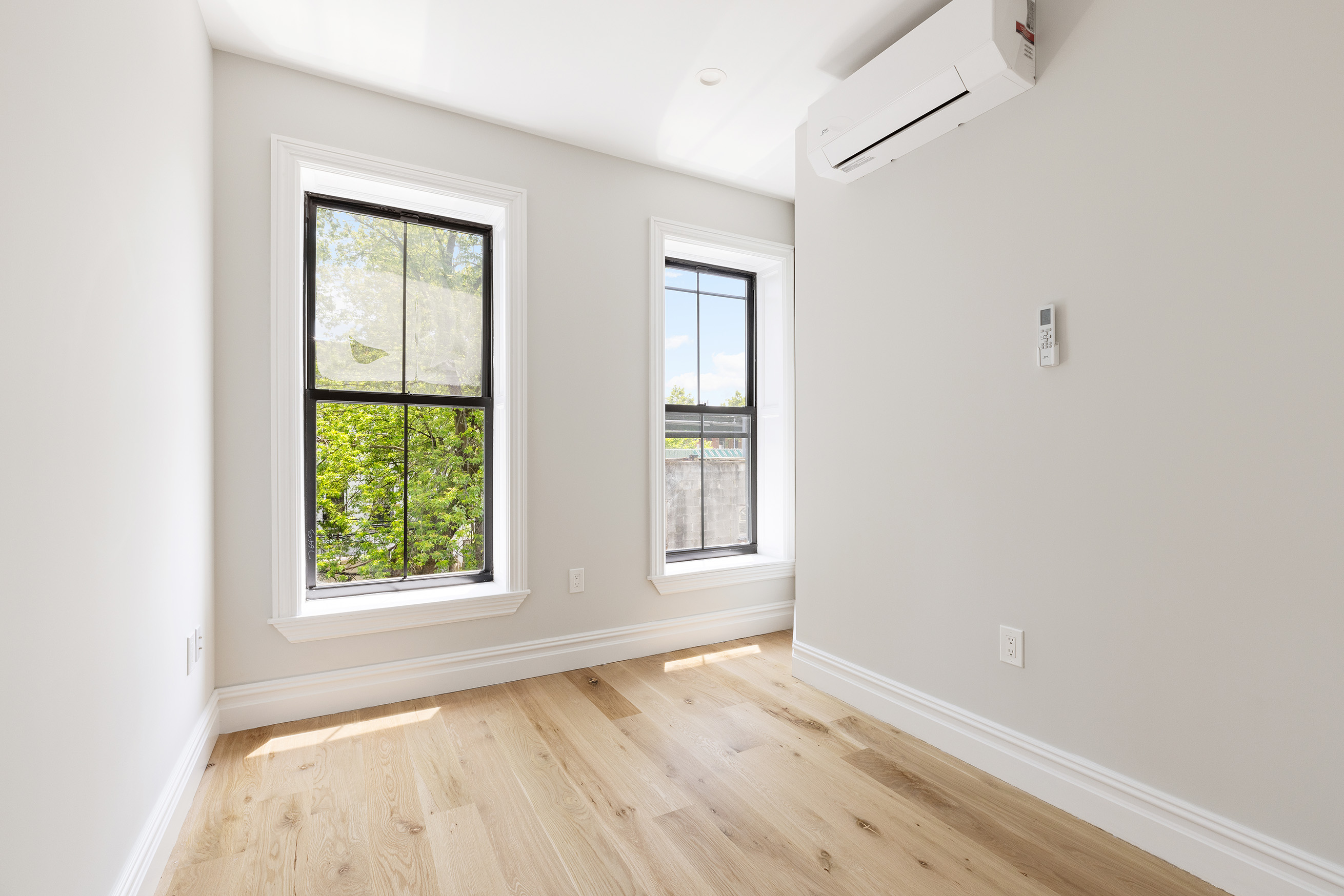 698 Macon Street Brooklyn, NY 11233 - Photo 12 of 17 an empty room with wooden floor and windows