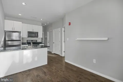 a large kitchen with granite countertop a refrigerator and a stove top oven