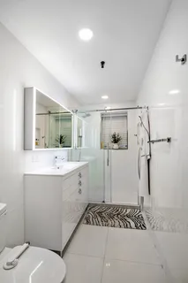 a bathroom with a sink a toilet and shower