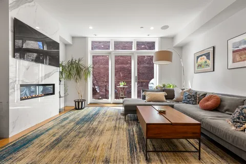a living room with furniture and a floor to ceiling window