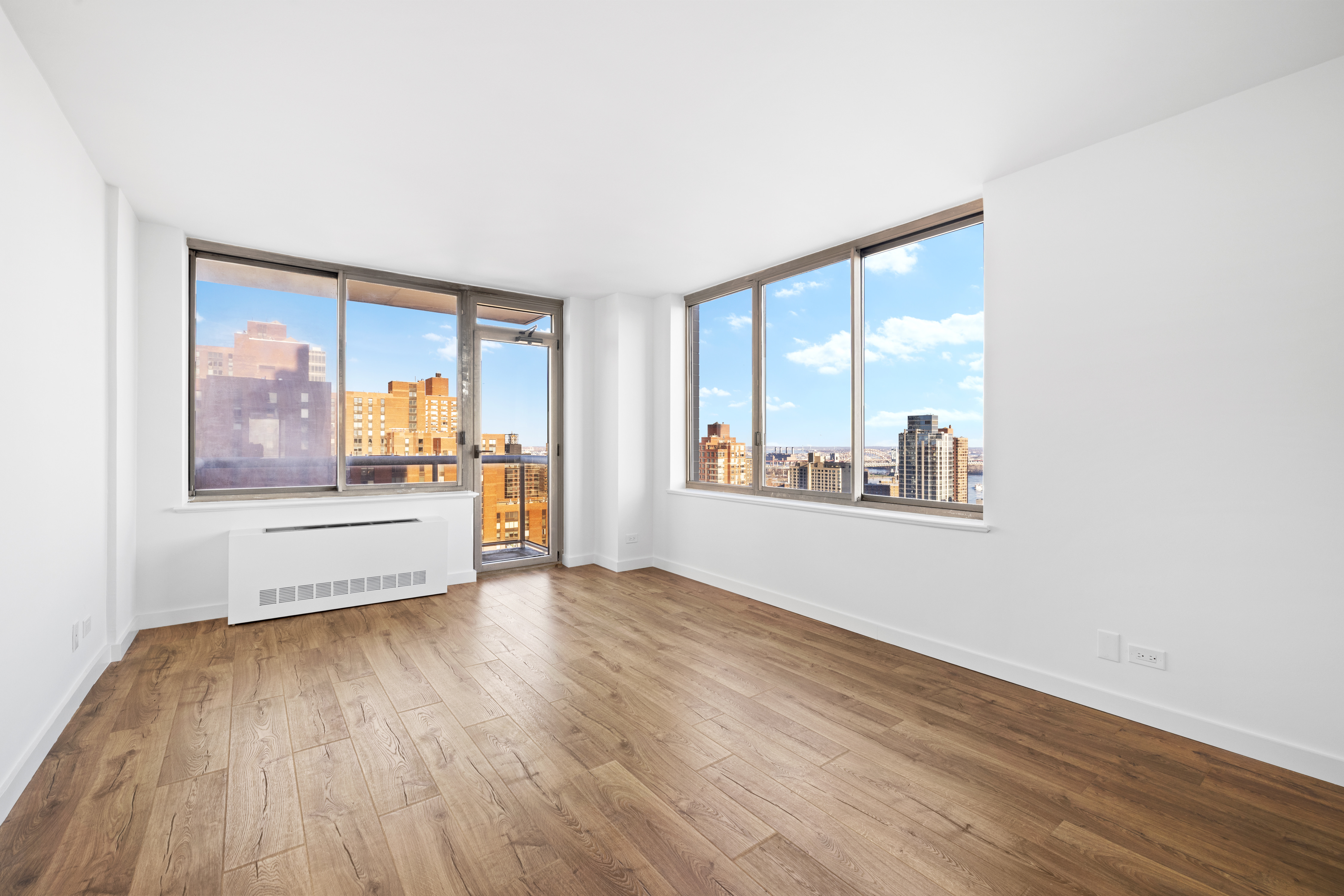 200 East 89th Street, Unit 29D Manhattan, NY 10128 - Photo 5 of 16 an empty room with wooden floor and a large window