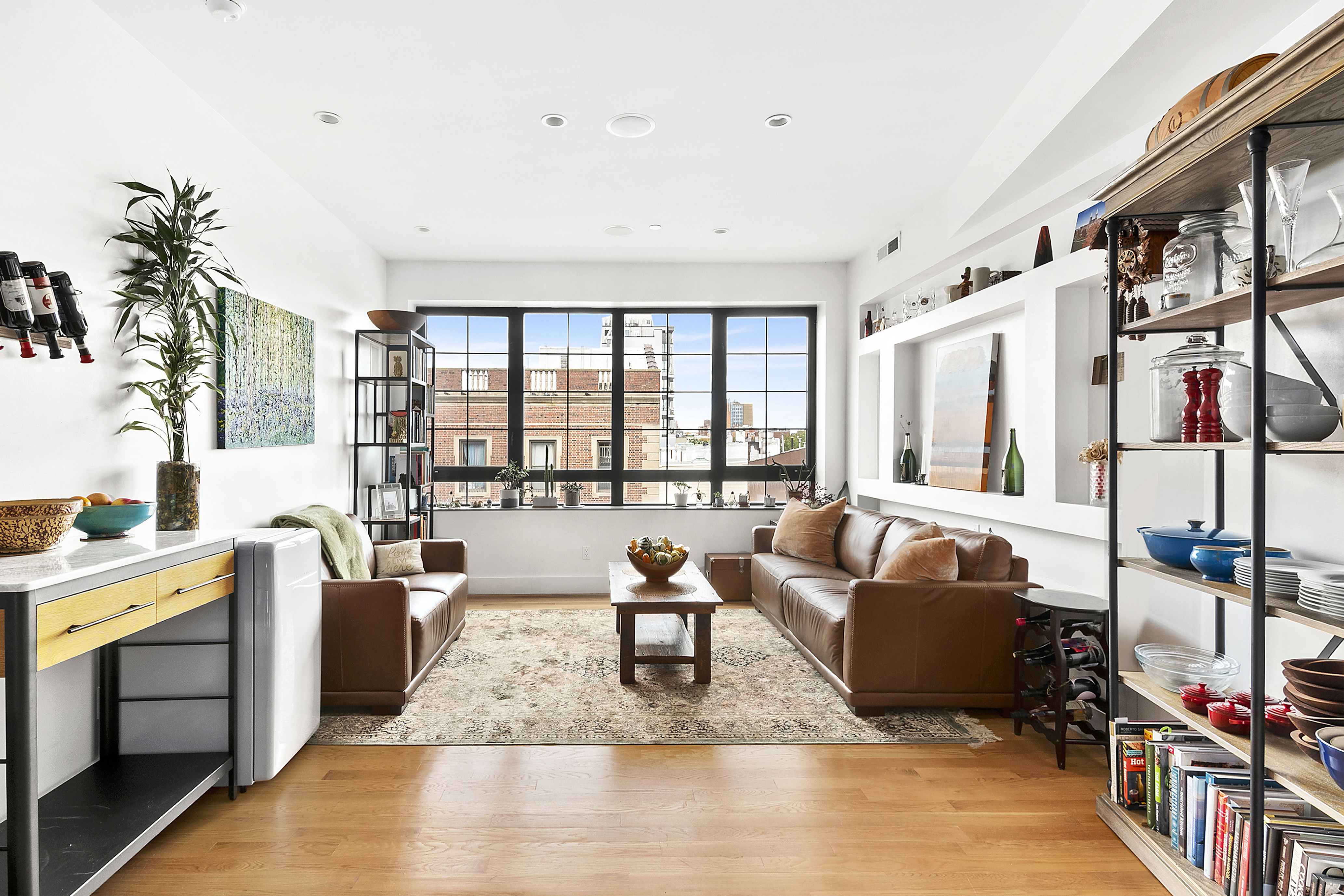 a living room with furniture a flat screen tv and a floor to ceiling window