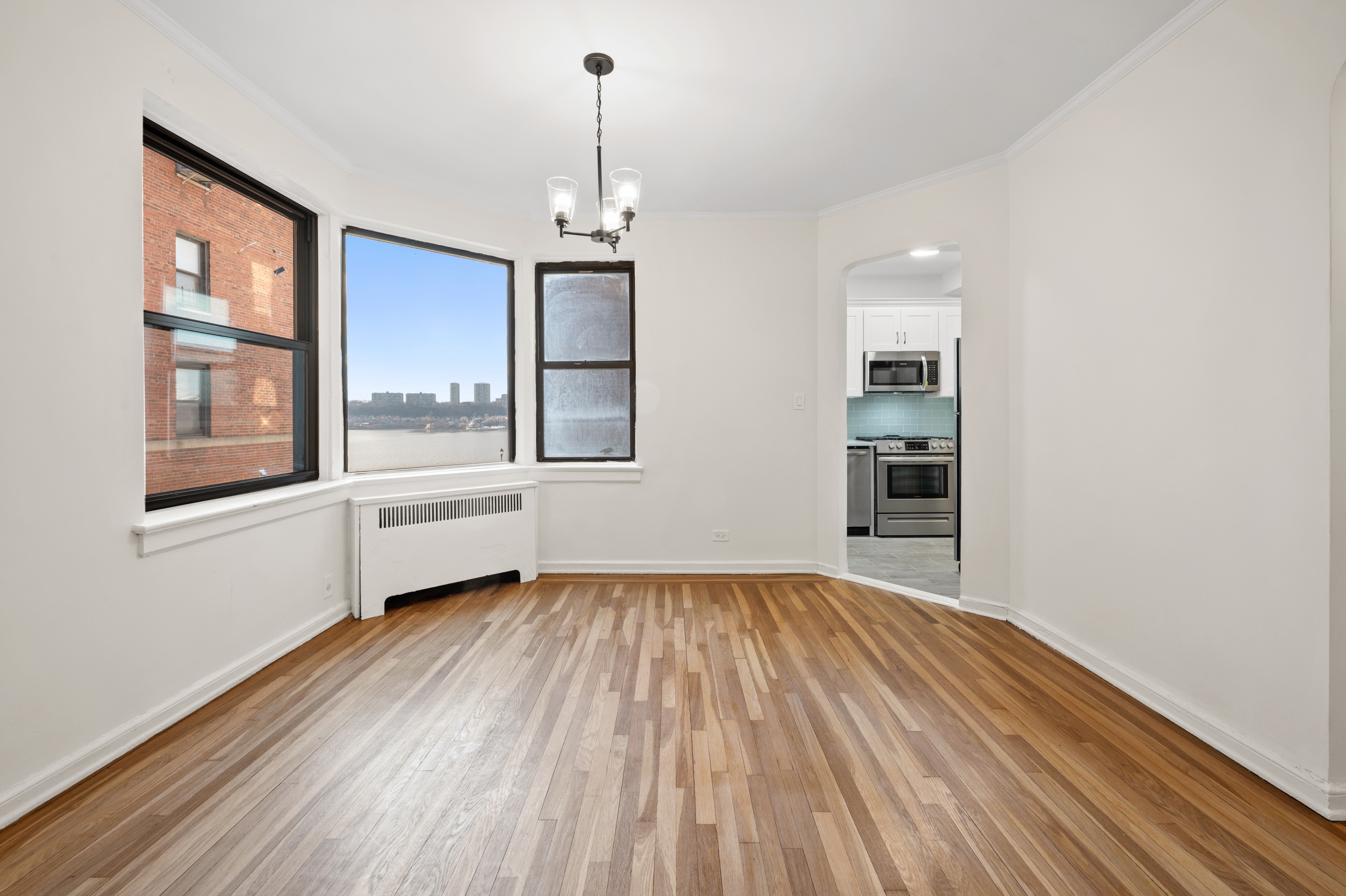 159-34 Riverside Drive West, Unit 3D Manhattan, NY 10032 - Photo 5 of 12 a view of empty room with wooden floor and fan