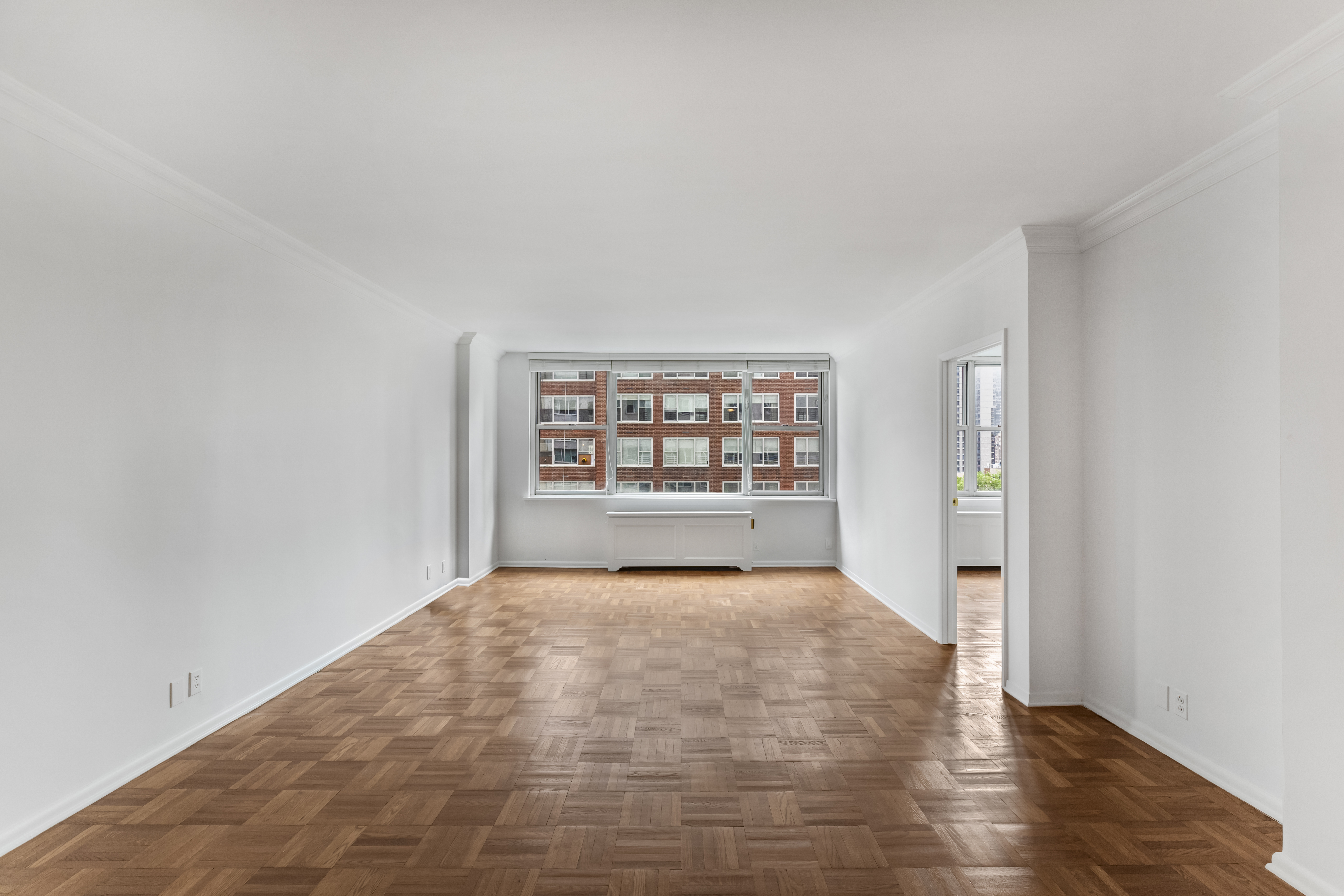 175 East 62nd Street, Unit 10B Manhattan, NY 10065 - Photo 8 of 12 a view of an empty room with a window and wooden floor