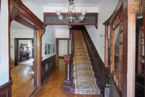 a view of a hallway with wooden floor and staircase