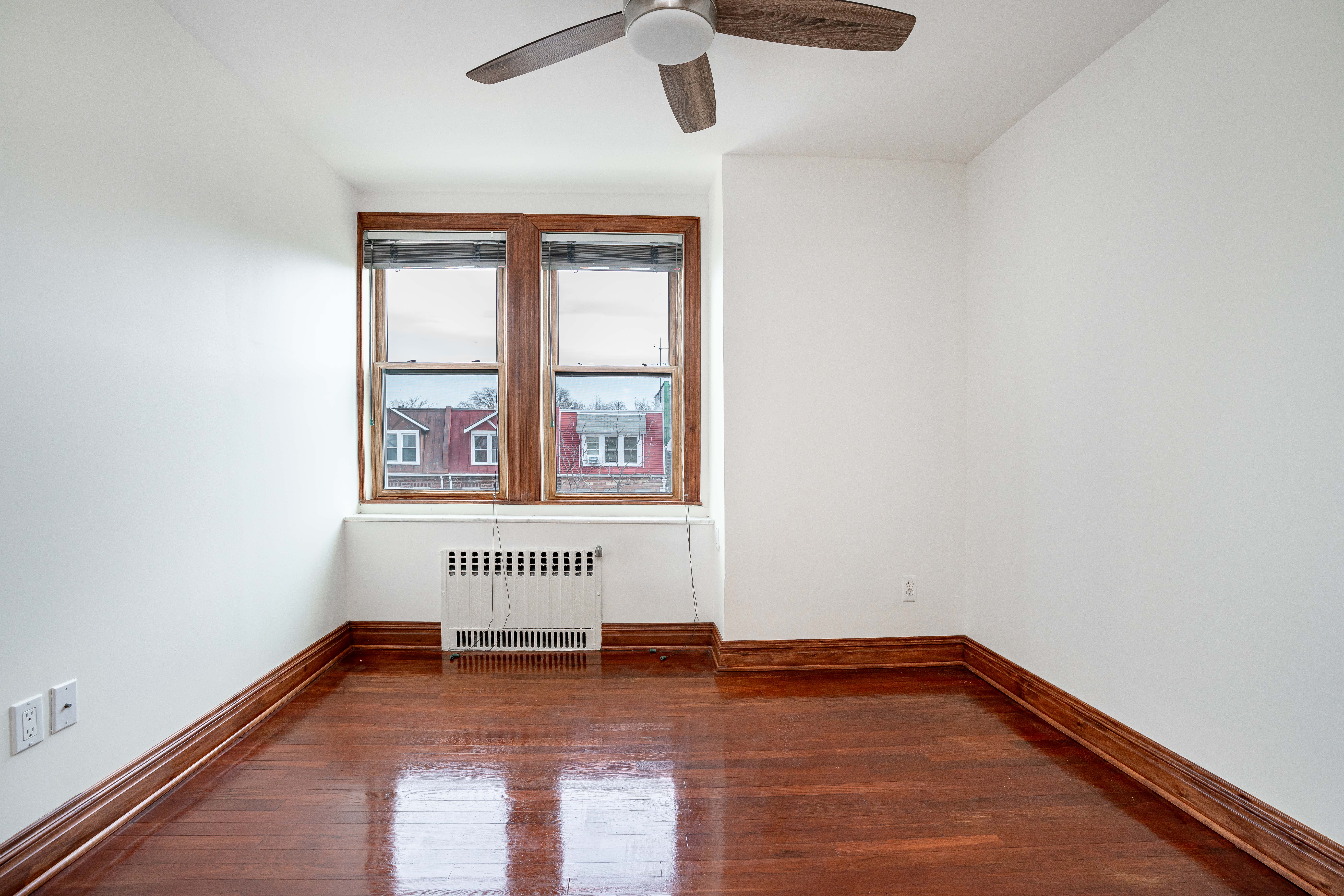 20-60 33rd Street, Unit 2 Queens, NY 11105 - Photo 8 of 10 an empty room with wooden floor chandelier and windows