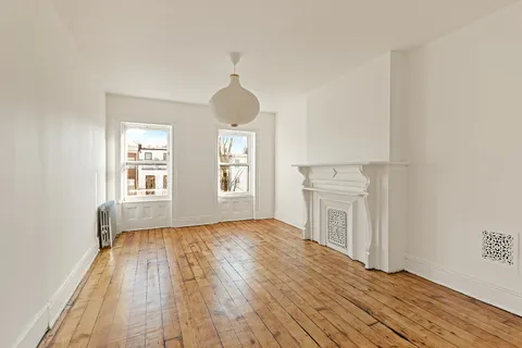 a view of a livingroom with wooden floor and a window