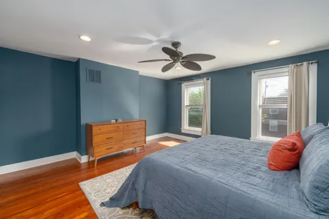 a bedroom with a bed and wooden floor