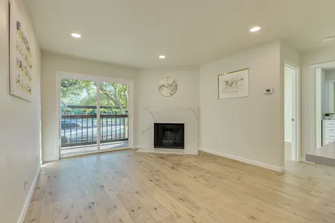 a view of an empty room with a fireplace and a window