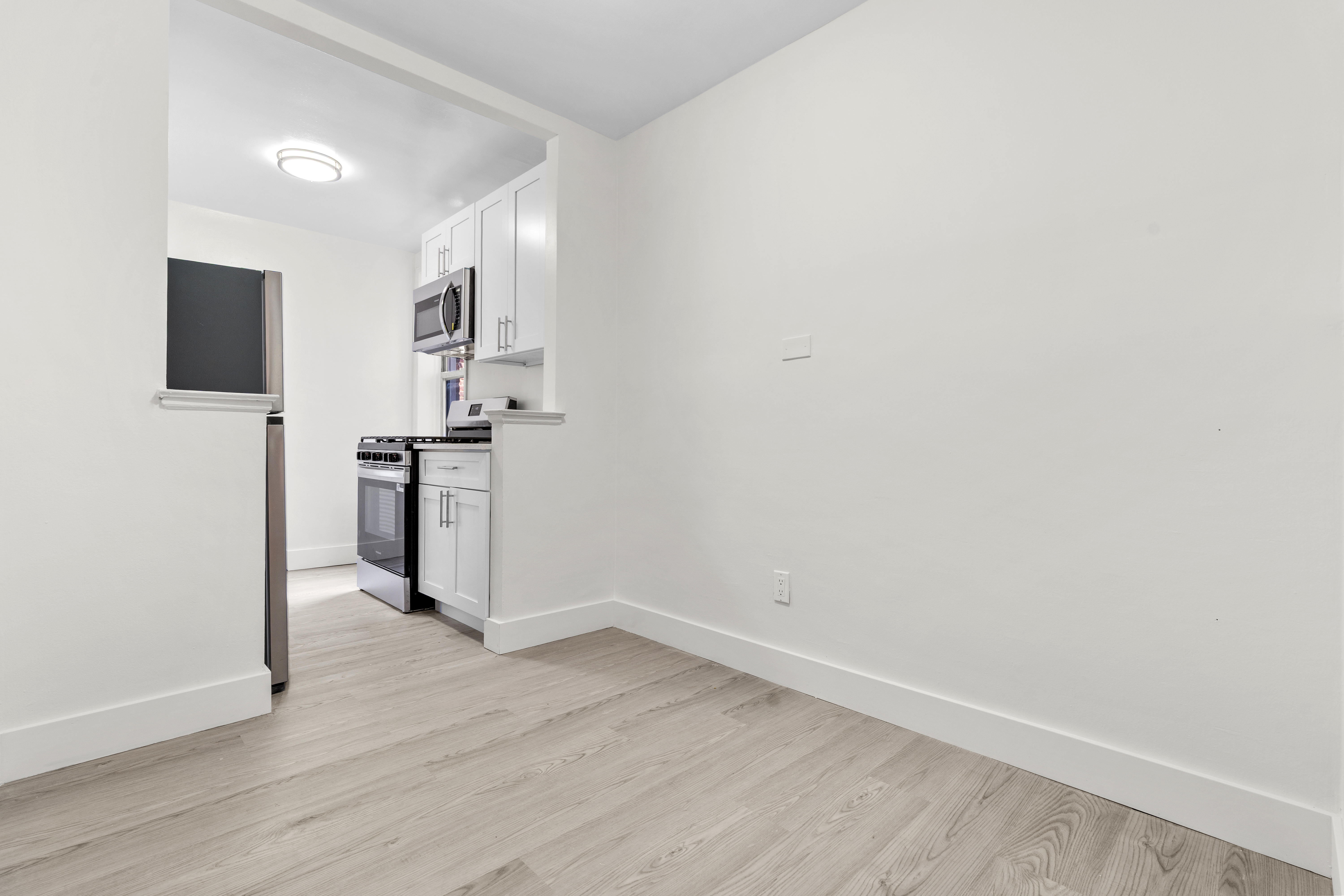 3165 Nostrand Avenue, Unit 1H Brooklyn, NY 11229 - Photo 7 of 9 a view of kitchen with wooden floor and electronic appliances