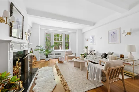 a living room with fireplace furniture and a large window