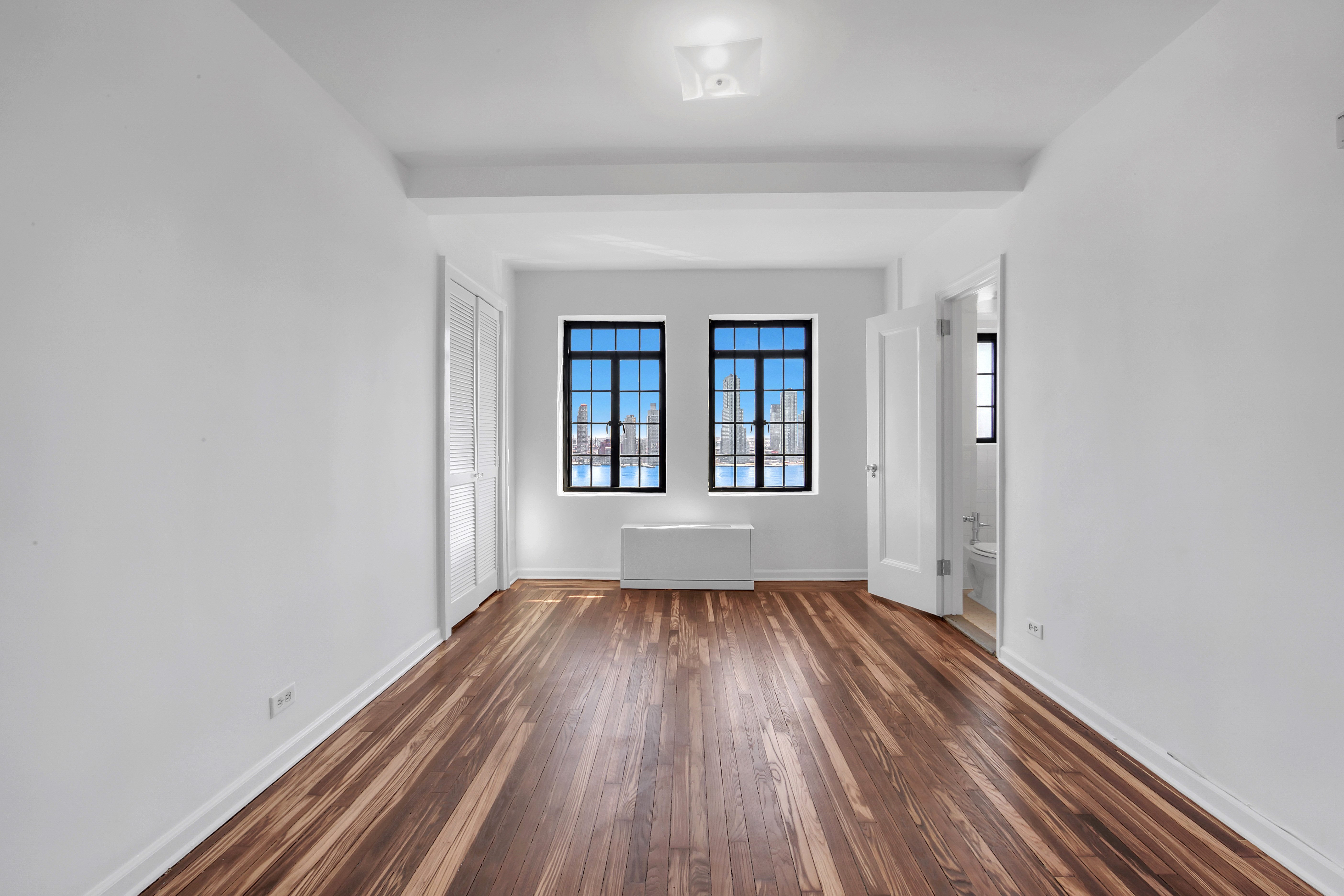 5 Tudor City Place, Unit 1126 Manhattan, NY 10017 - Photo 6 of 20 wooden floor in an empty room with a window
