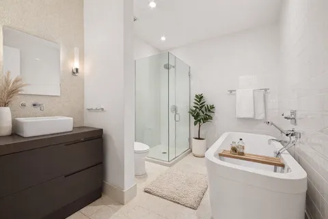 a bathroom with a sink a toilet and shower