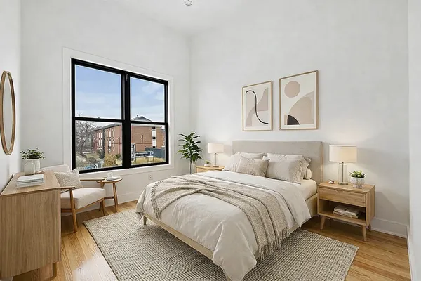 a bedroom with a bed and a large window