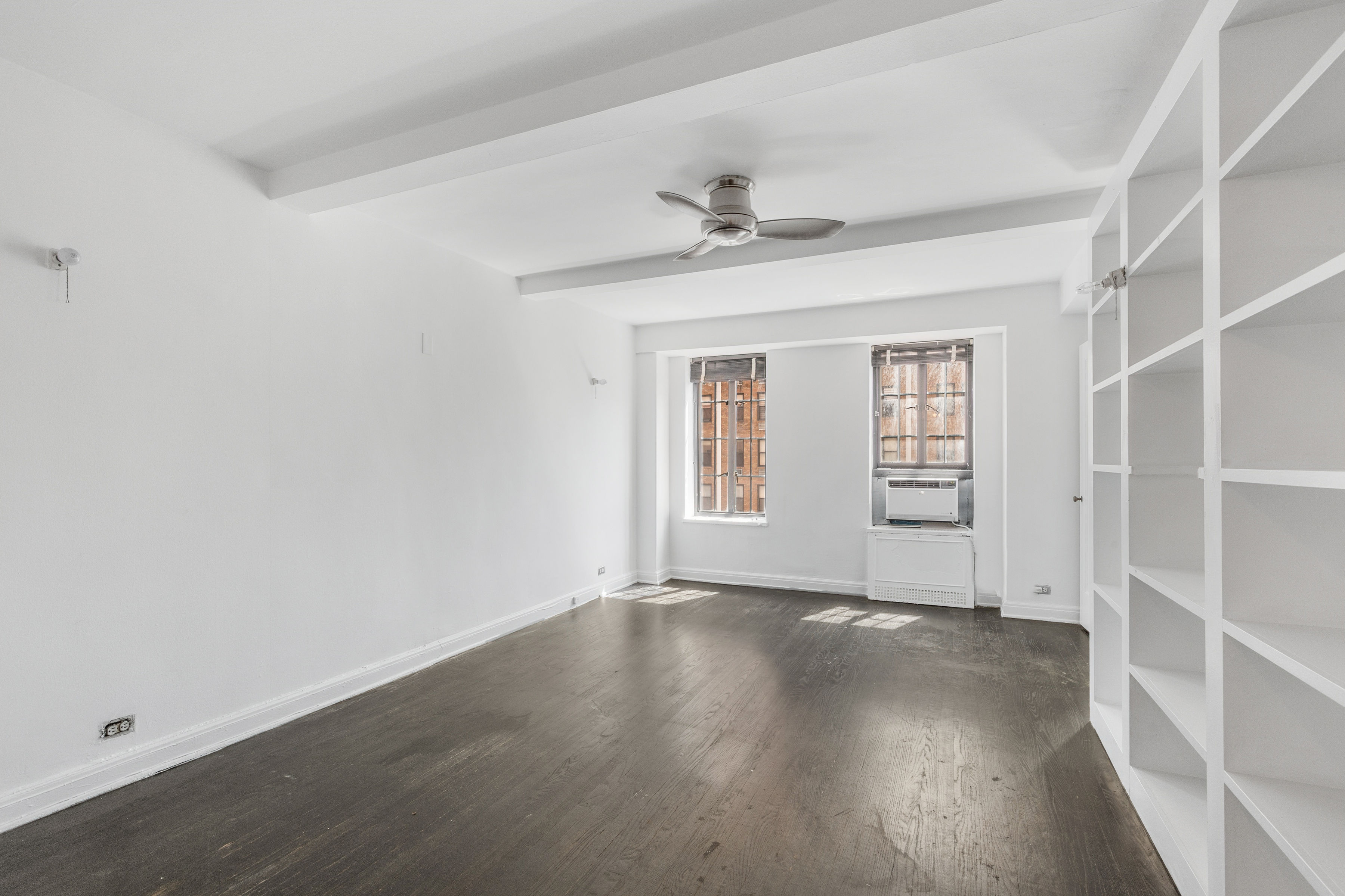 201 West 16th Street, Unit 7C Manhattan, NY 10011 - Photo 2 of 8 a view of an empty room with a window and wooden floor