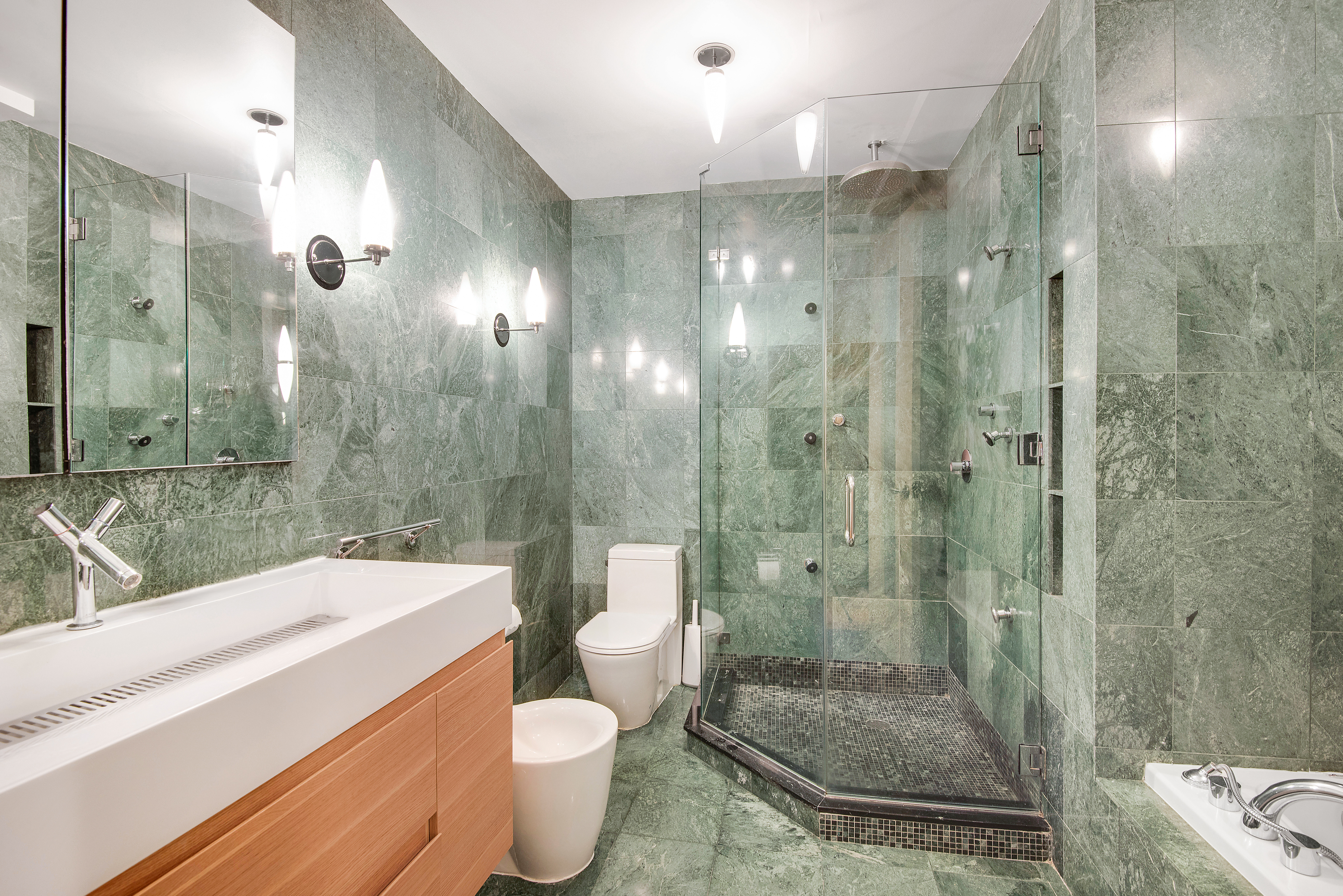 434 East 52nd Street, Unit 1BH Manhattan, NY 10022 - Photo 9 of 23 a bathroom with a sink a toilet and shower