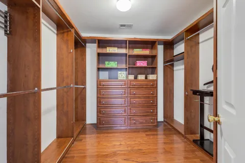 a view of walk in closet with clothes and shoes