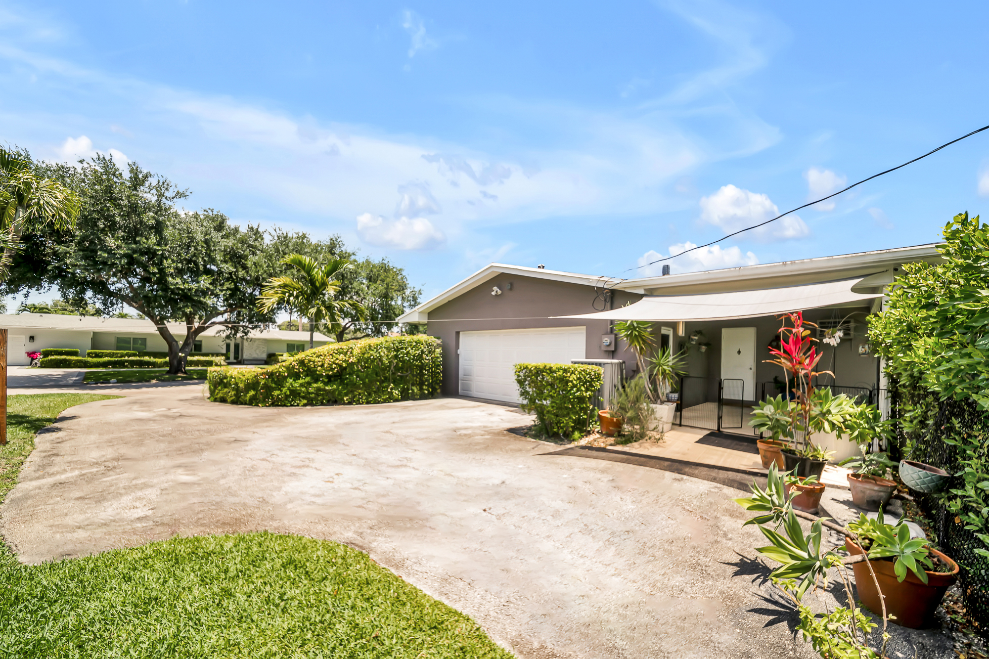 6760 Southwest 62nd Terrace Miami, FL 33143 - Photo 20 of 38 a front view of a house with a yard and potted plants