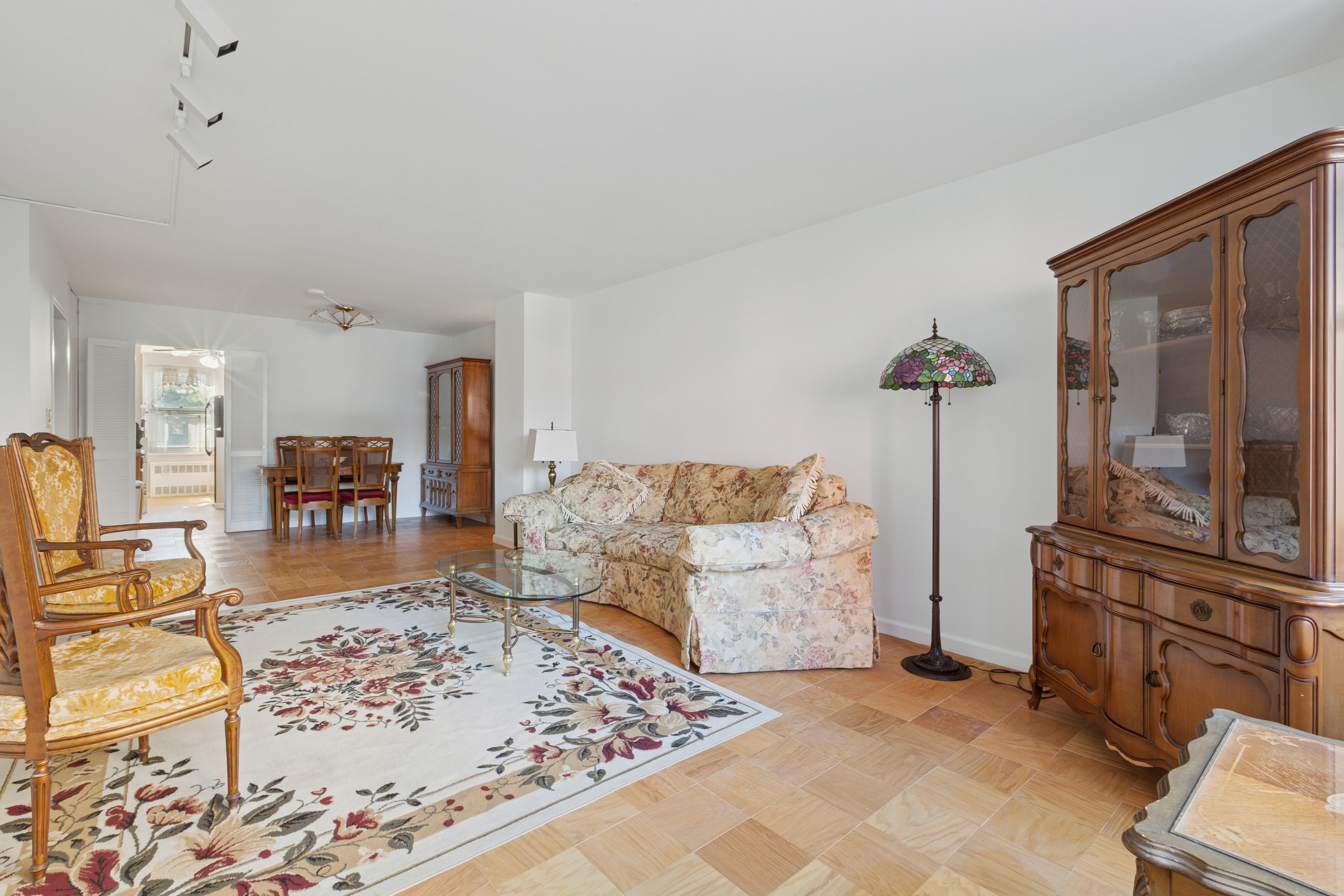70-25 Yellowstone Boulevard, Unit 2M Queens, NY 11375 - Photo 4 of 23 a living room with furniture and a flat screen tv