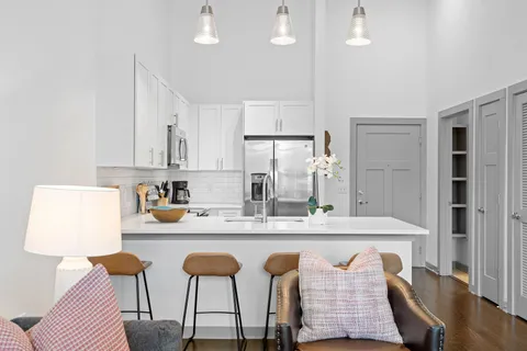 a kitchen with stainless steel appliances kitchen island granite countertop a table chairs sink and cabinets