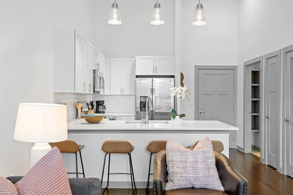 a kitchen with stainless steel appliances kitchen island granite countertop a table chairs sink and cabinets