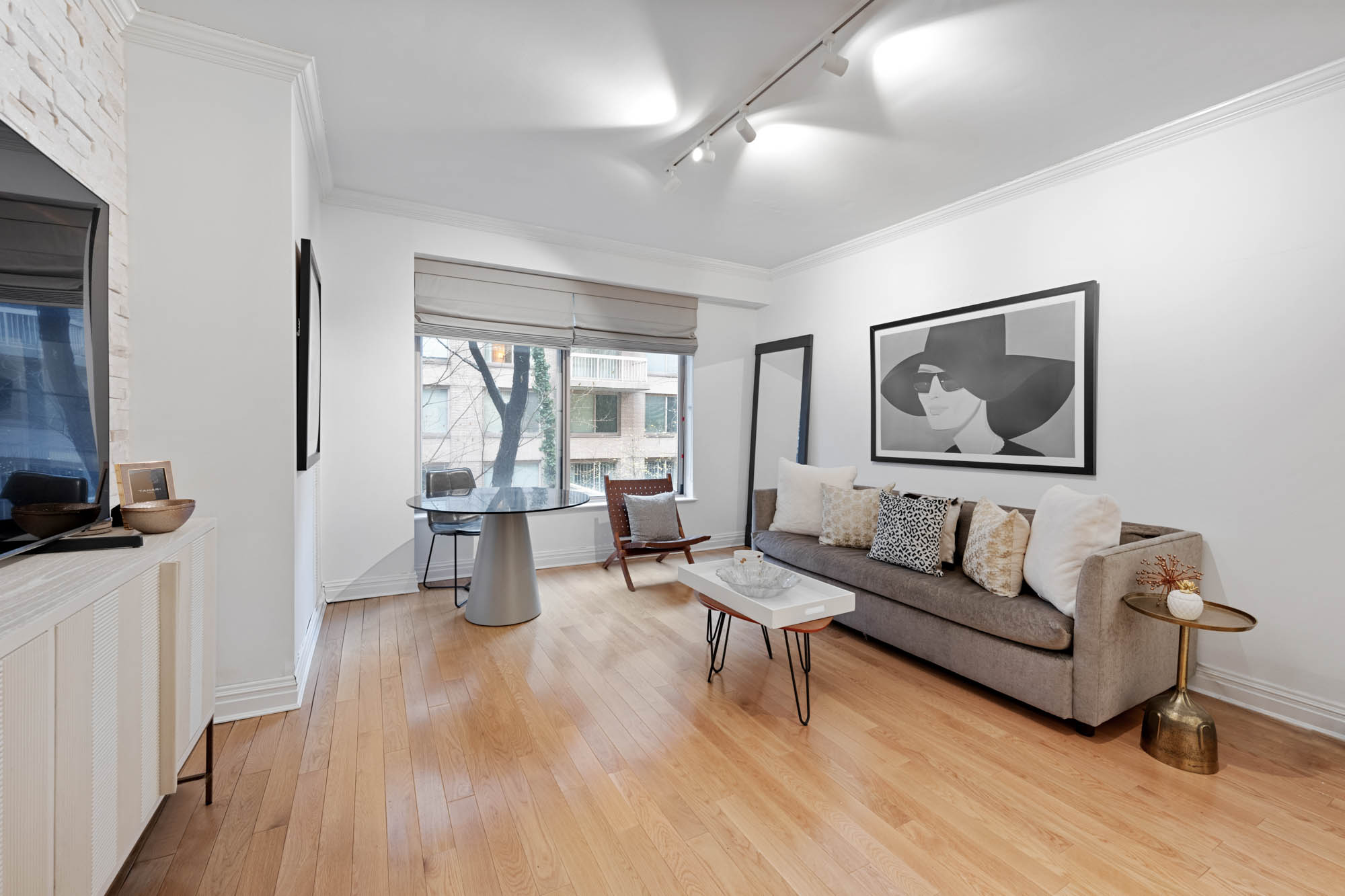 a living room with couches a coffee table and a large mirror with wooden floor