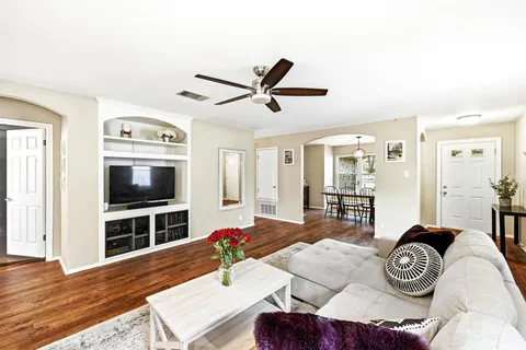 a living room with furniture and a wooden floor