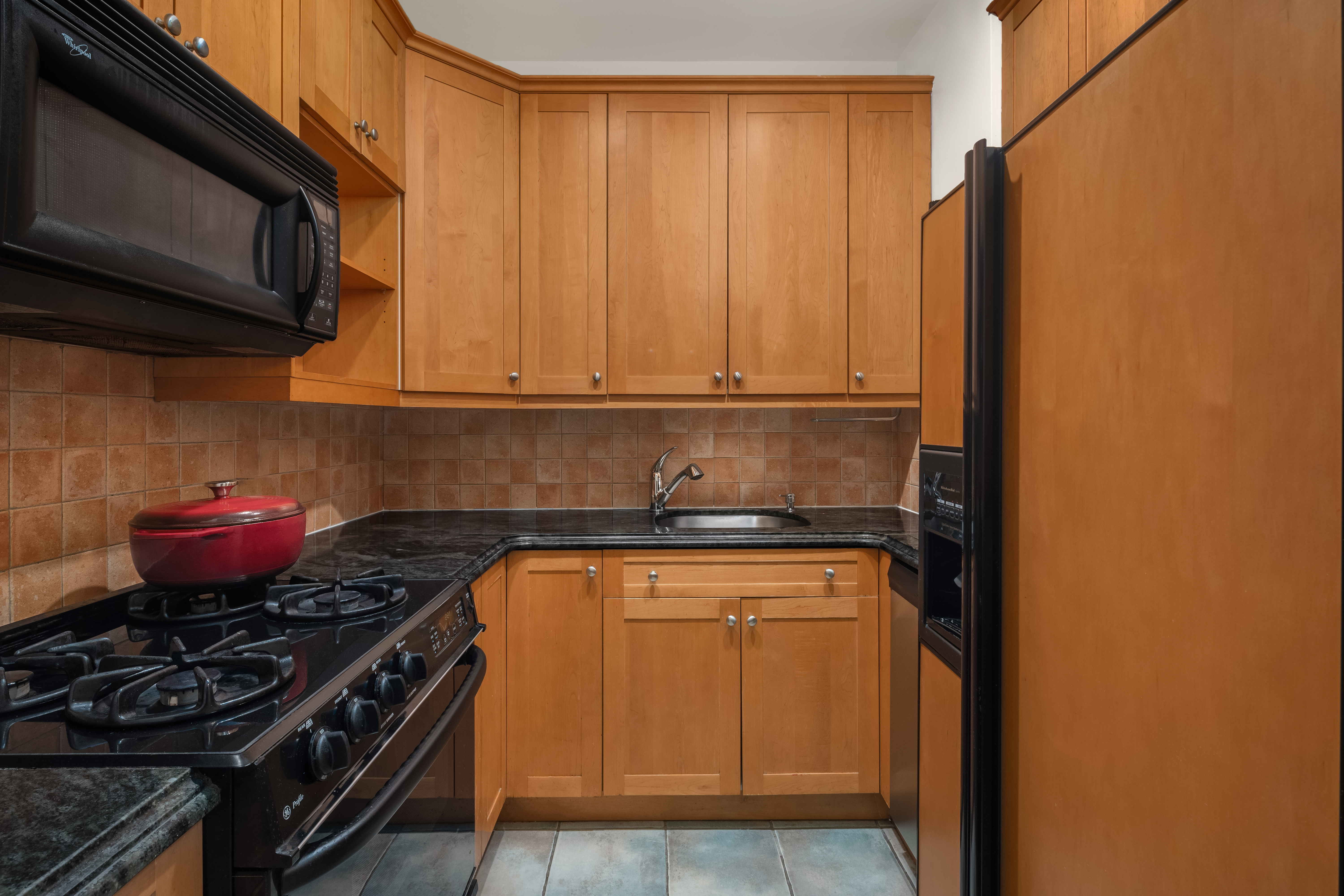 3 Hanover Square, Unit 4E Manhattan, NY 10004 - Photo 4 of 7 a kitchen with a stove and a microwave