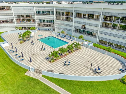 a large hall with stainless steel appliances granite countertop a rug stove and white cabinets