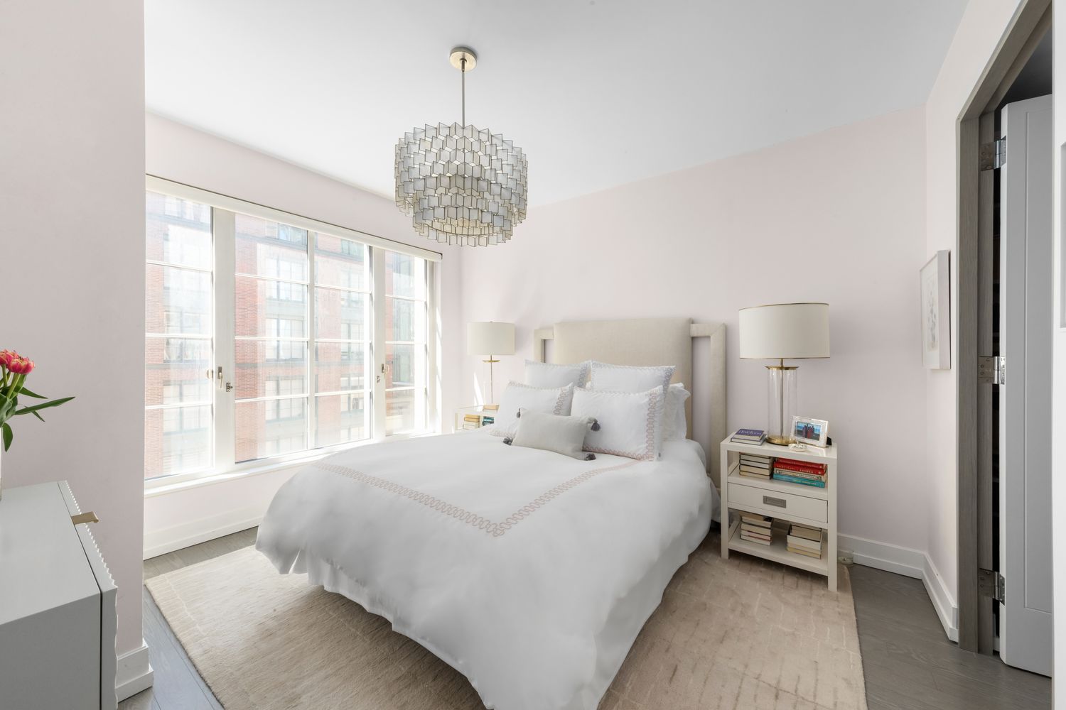 70 Charlton Street, Unit 19D Manhattan, NY 10014 - Photo 5 of 14 a bedroom with a large bed and a chandelier