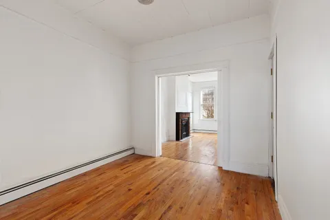 a view of empty room with wooden floor