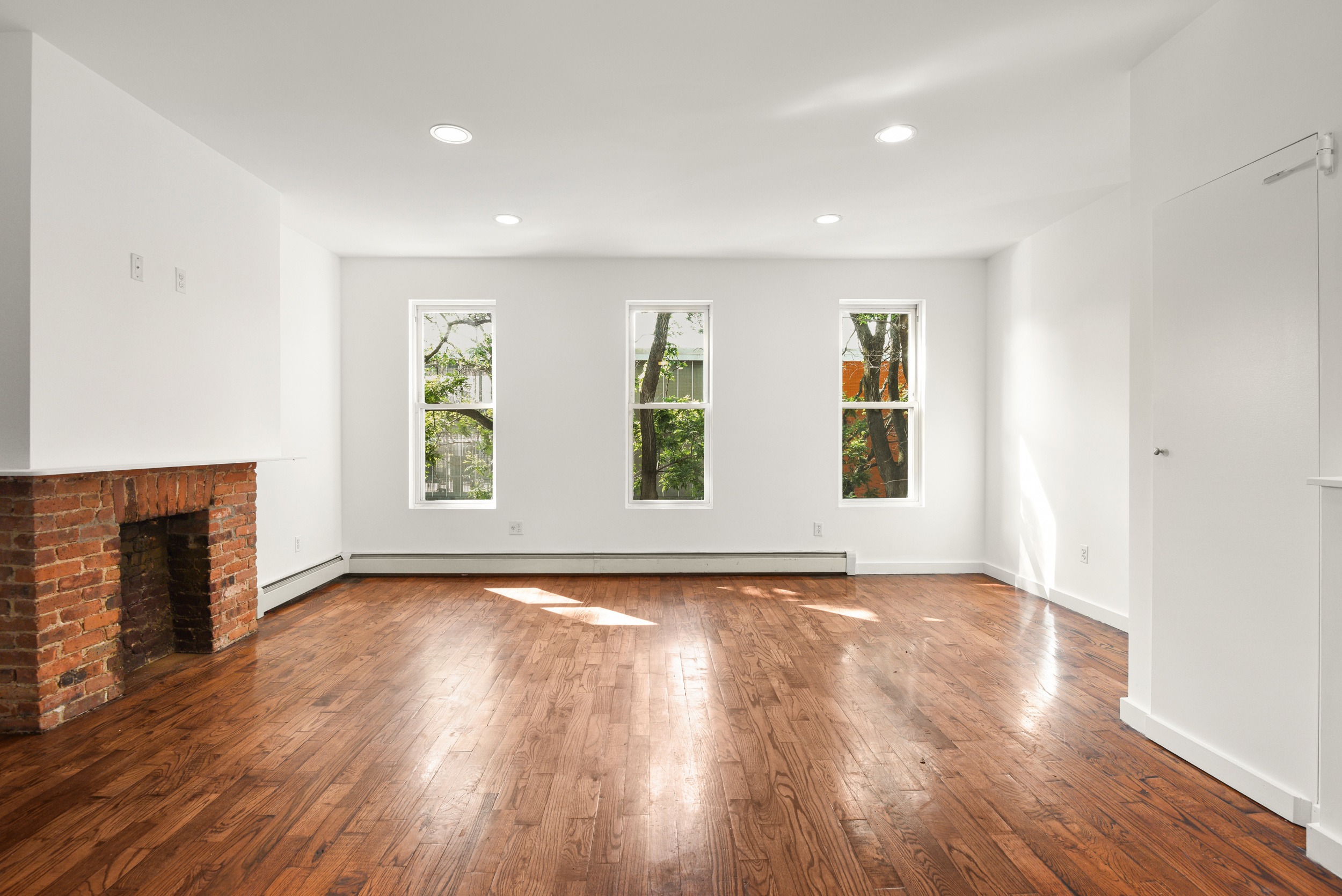 1076 Decatur Street, Unit 2 Brooklyn, NY 11207 - Photo 2 of 11 an empty room with wooden floor and windows