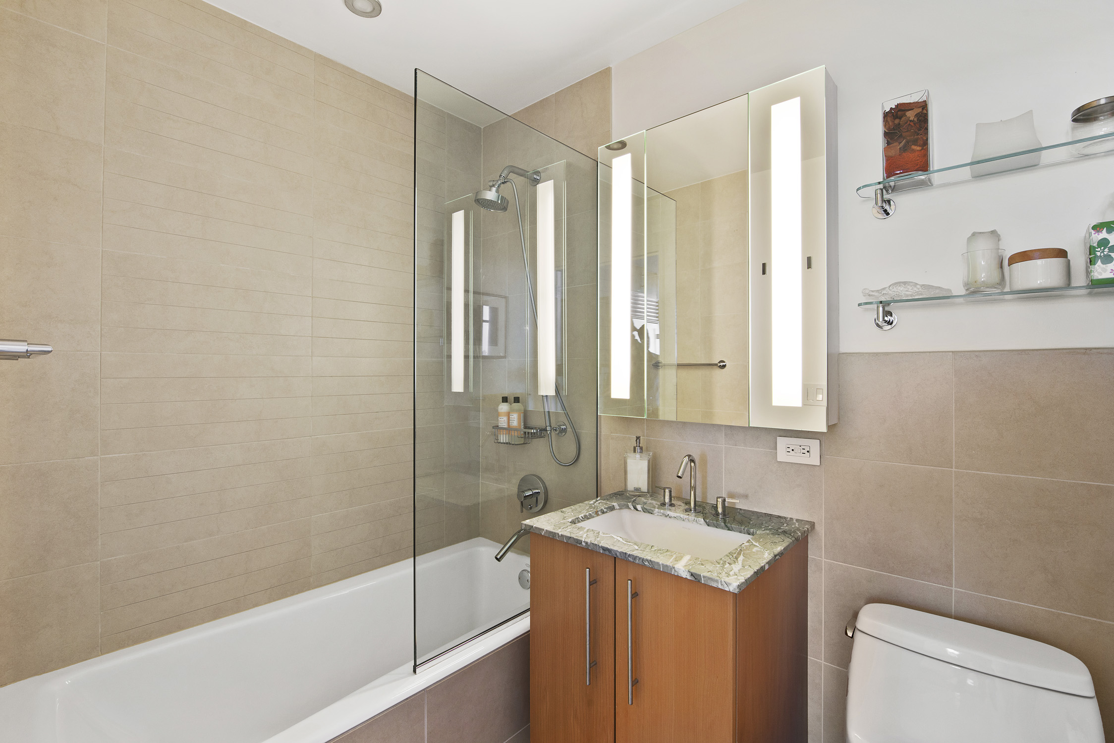 1 Northside Piers, Unit 25D Brooklyn, NY 11249 - Photo 11 of 19 a bathroom with a granite countertop sink a mirror a bathtub and shower