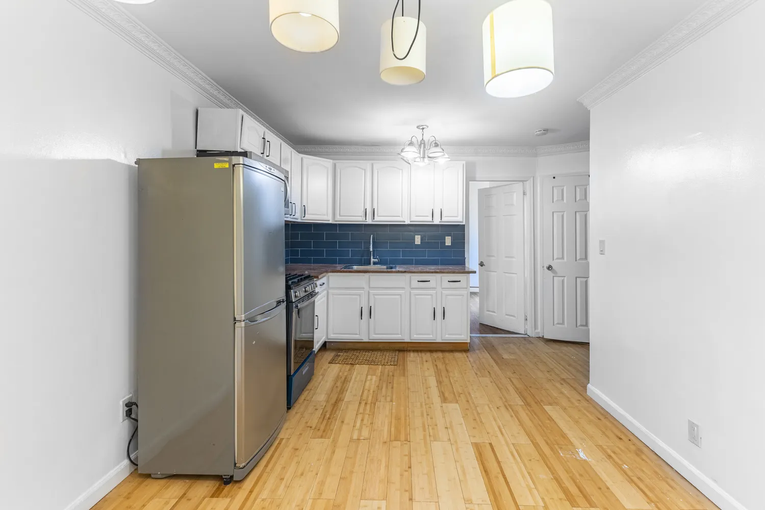 a kitchen with a refrigerator a sink and cabinets