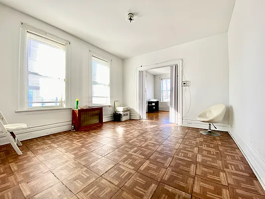 a view of a livingroom with wooden floor and furniture