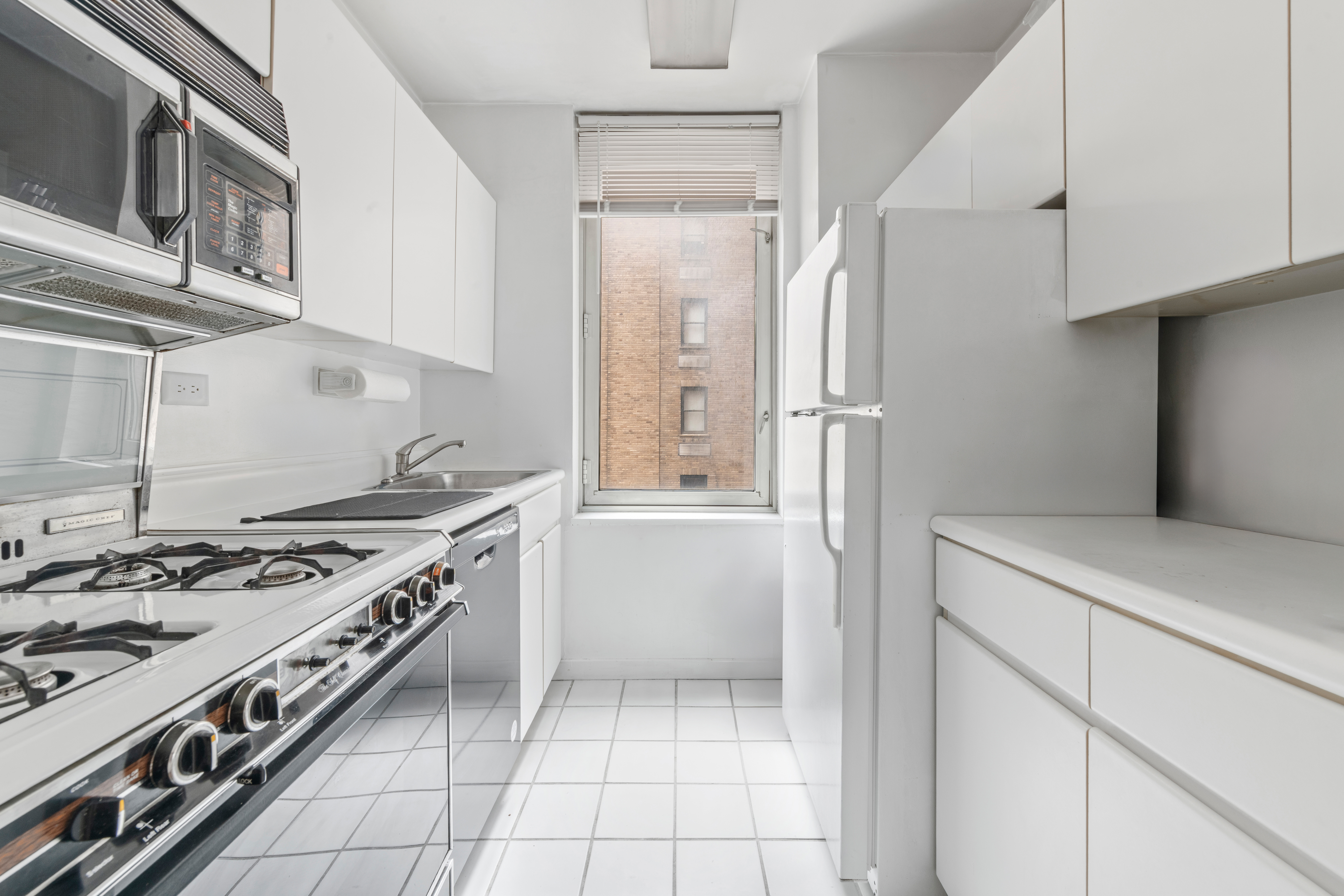 145 East 48th Street, Unit 12B Manhattan, NY 10017 - Photo 5 of 7 a kitchen with a stove and a refrigerator