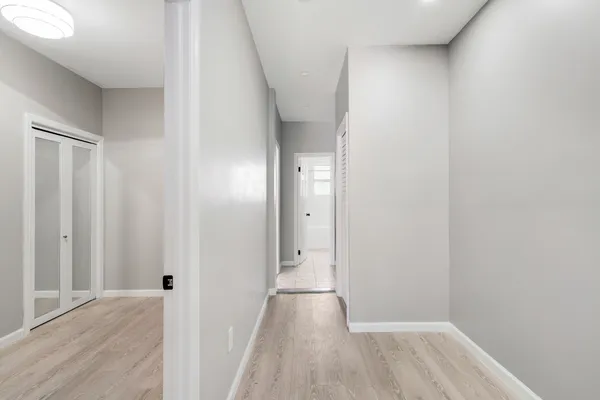a view of an empty room with closet and a window