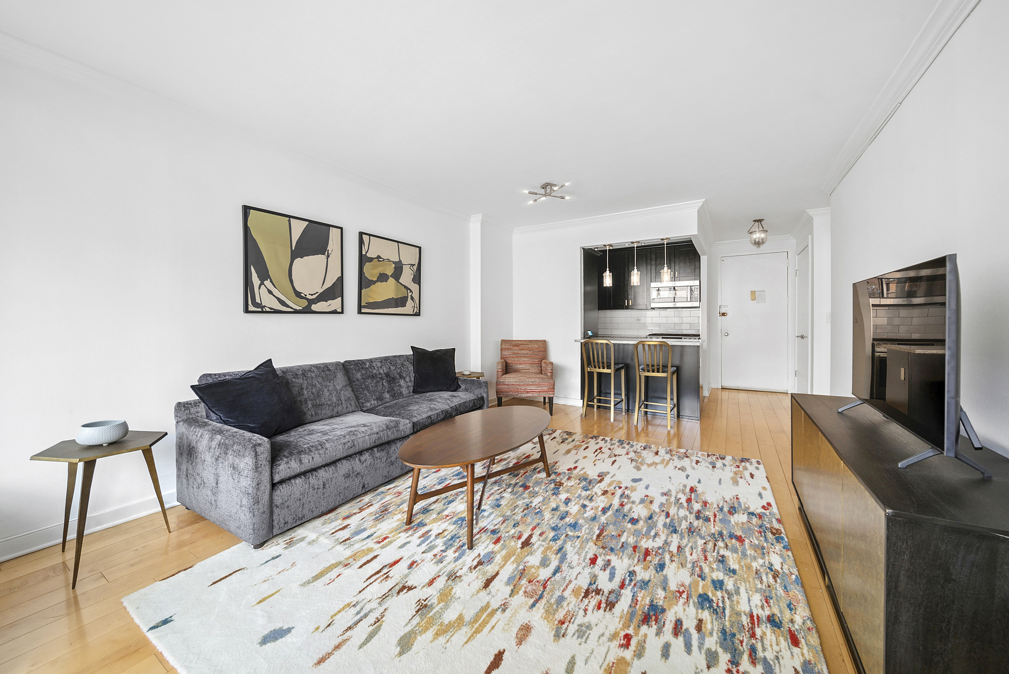 150 East 85th Street, Unit 5F Manhattan, NY 10028 - Photo 5 of 9 a living room with furniture and a flat screen tv