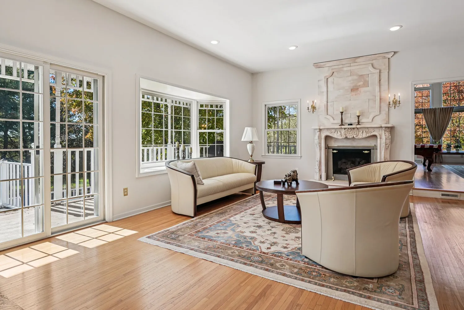 a living room with furniture a fireplace and a floor to ceiling window