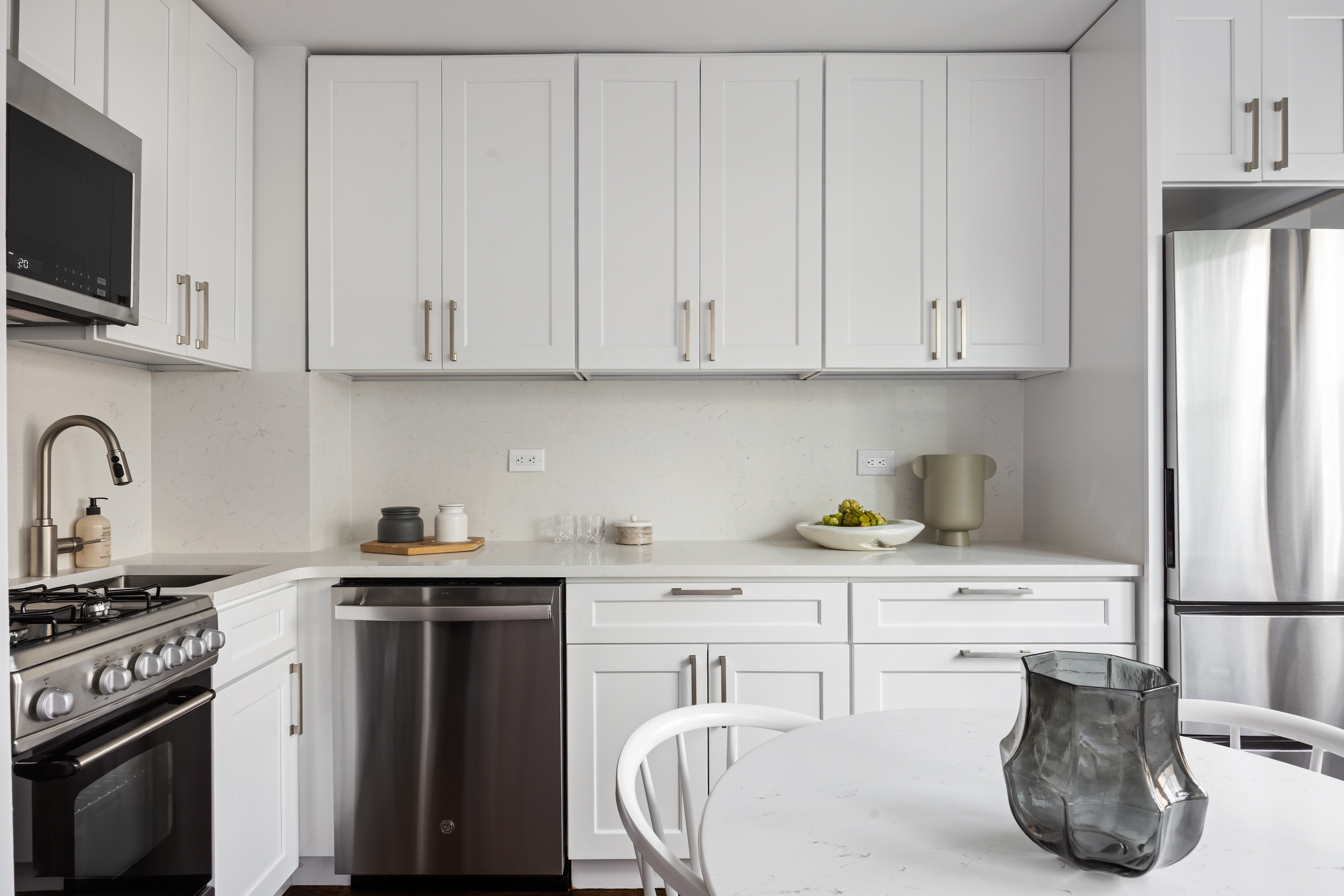 166 East 35th Street, Unit 5F Manhattan, NY 10016 - Photo 5 of 11 a kitchen with stainless steel appliances granite countertop a sink a stove and cabinets