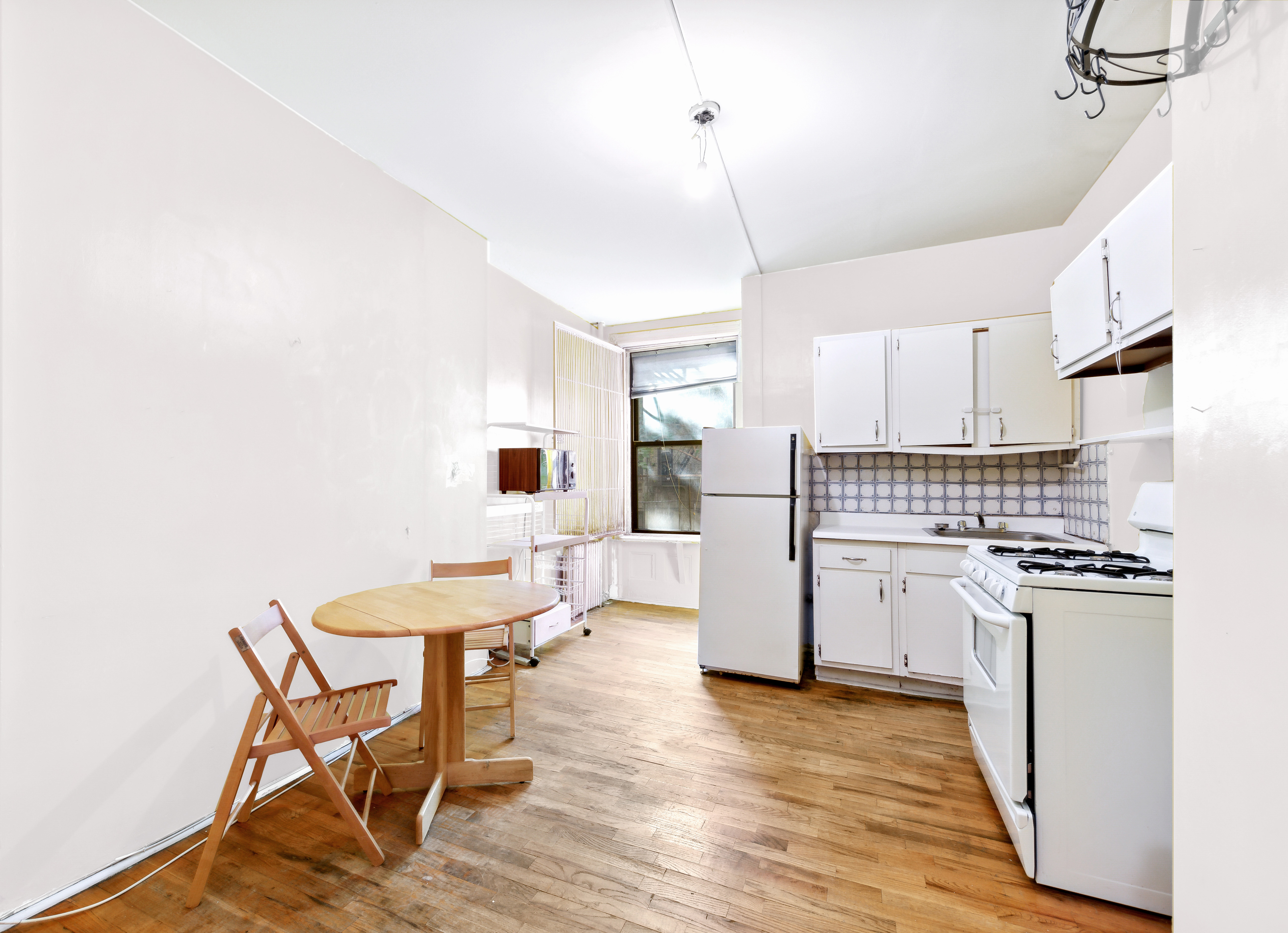 206 East 90th Street, Unit 2E Manhattan, NY 10128 - Photo 7 of 13 a kitchen with furniture and wooden floor