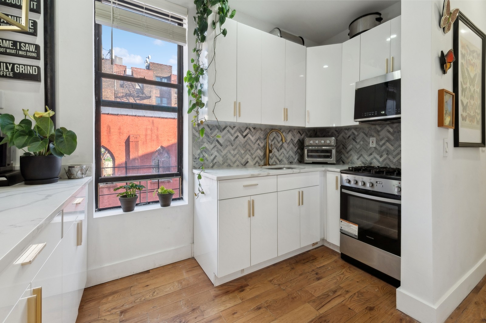 66 West 138th Street, Unit 3A Manhattan, NY 10037 - Photo 3 of 8 a kitchen with stainless steel appliances white cabinets and a stove top oven
