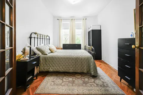 a bedroom with a bed window and a television