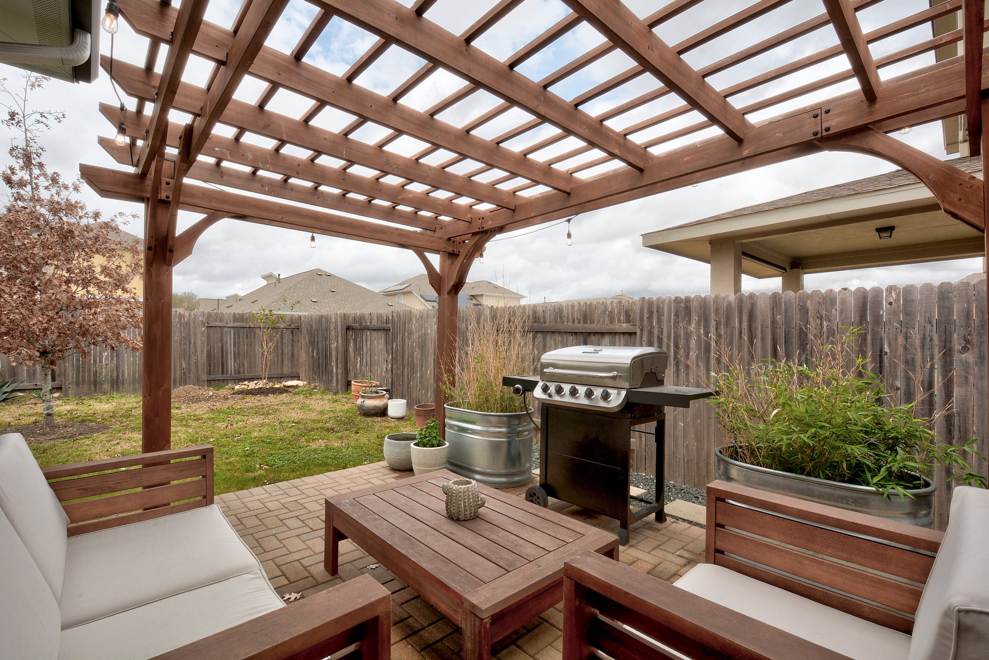 5400 Daimler Drive Austin, TX 78744 - Photo 23 of 27 a view of a patio with table and chairs under an umbrella with a small yard