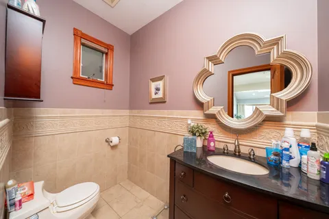 a bathroom with a toilet a sink and mirror