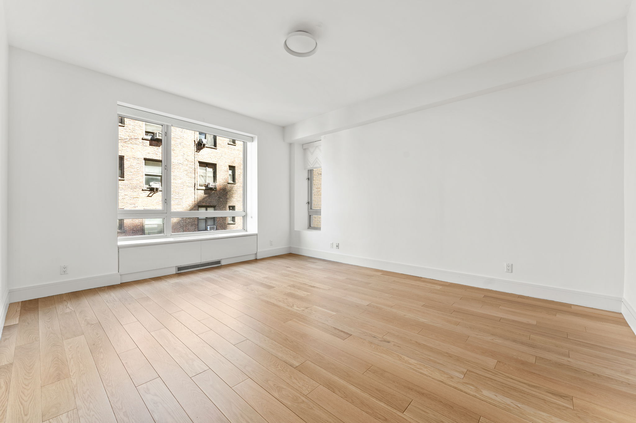 545 West 110th Street, Unit 5A Manhattan, NY 10025 - Photo 18 of 20 an empty room with wooden floor and windows