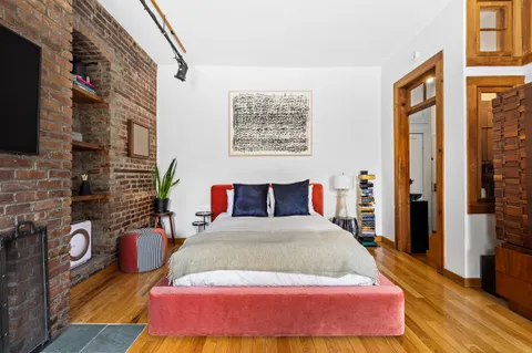 a bedroom with a bed and wooden floor