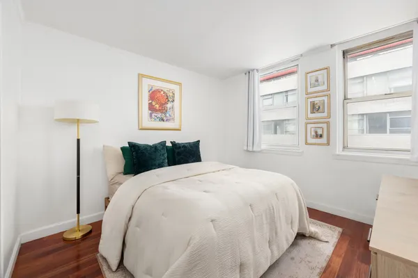 a large bed sitting in a bedroom next to a window